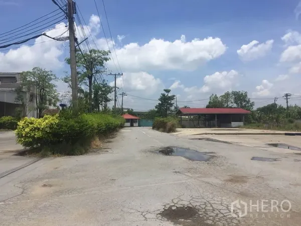 Office Space for rent in Sai Noi, Nonthaburi - Internal road and parking court with greenery and red‑roof shelters in a quiet compound.