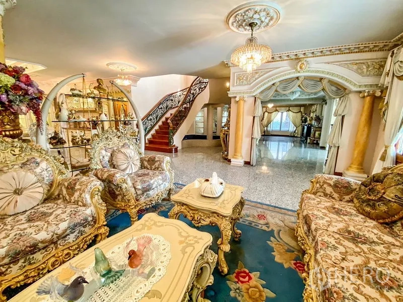 独立式住宅 出租或出售在Bang Khen, Bangkok - 大客厅，古典沙发、拱形门廊与锻铁弧形楼梯。