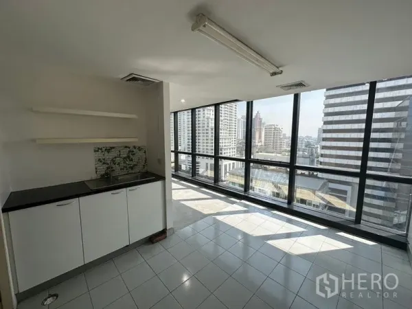 Office Space for rent in Khlong Toei, Bangkok - Pantry with sink and cabinets beside full-height glass windows overlooking the city.
