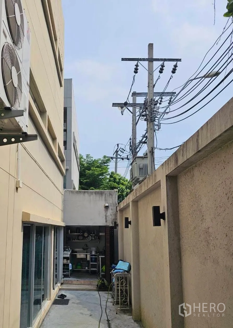 联排别墅 for sale in Suan Luang, Bangkok - 侧边服务庭院，带水槽、收纳架与混凝土通道。