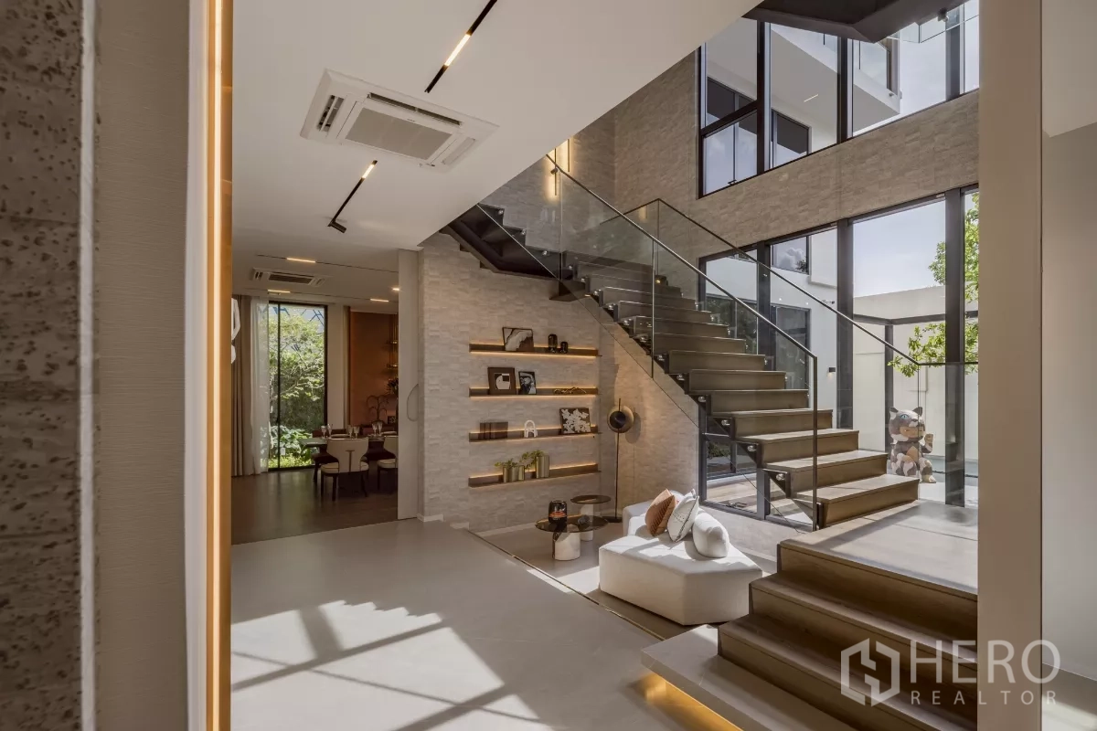 Detached House for rent in Saphan Sung, Bangkok - Bright foyer featuring glass‑railed staircase, display niches and garden views.