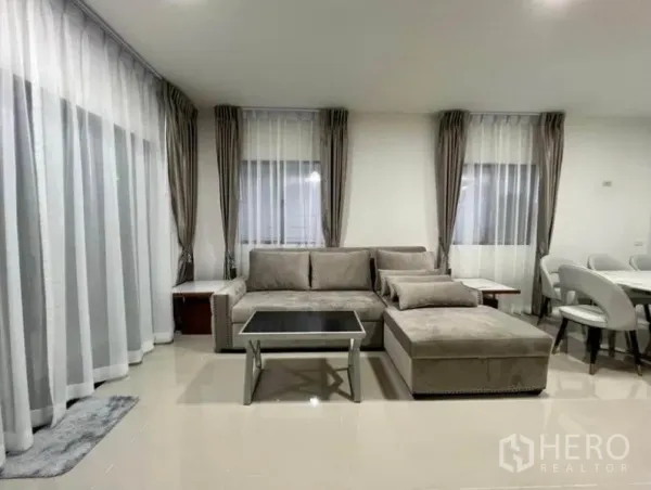 ทาวน์เฮาส์ ให้เช่าในWang Thonglang, Bangkok - มุมนั่งเล่นอบอุ่น โซฟารูปตัวแอล โต๊ะกลาง และผ้าม่านเต็มความสูง