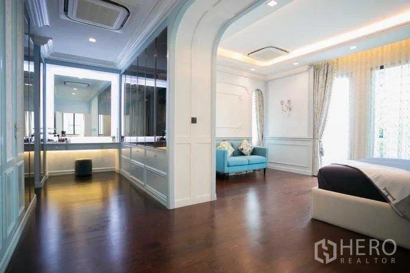 Detached House for rent in Bangkok - Primary bedroom suite with wood floors, cove lighting, dressing area and balcony doors.