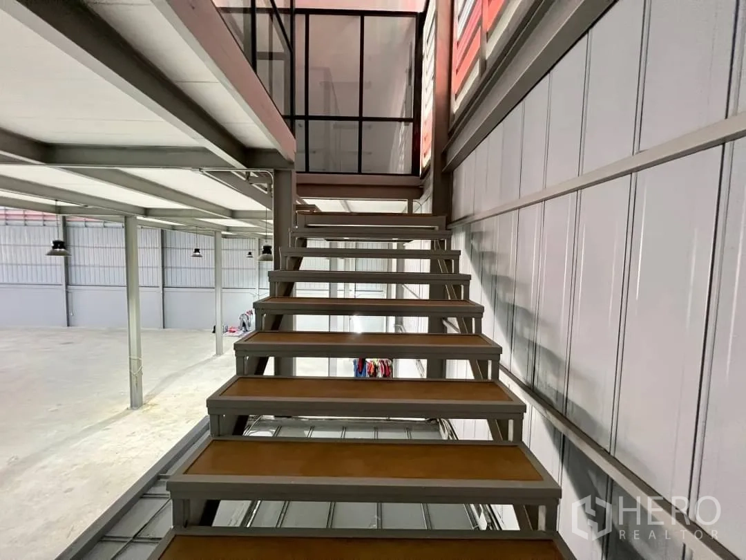 货栈 出租在Sai Mai, Bangkok - 金属楼梯通向夹层，旁设通风百叶墙面。