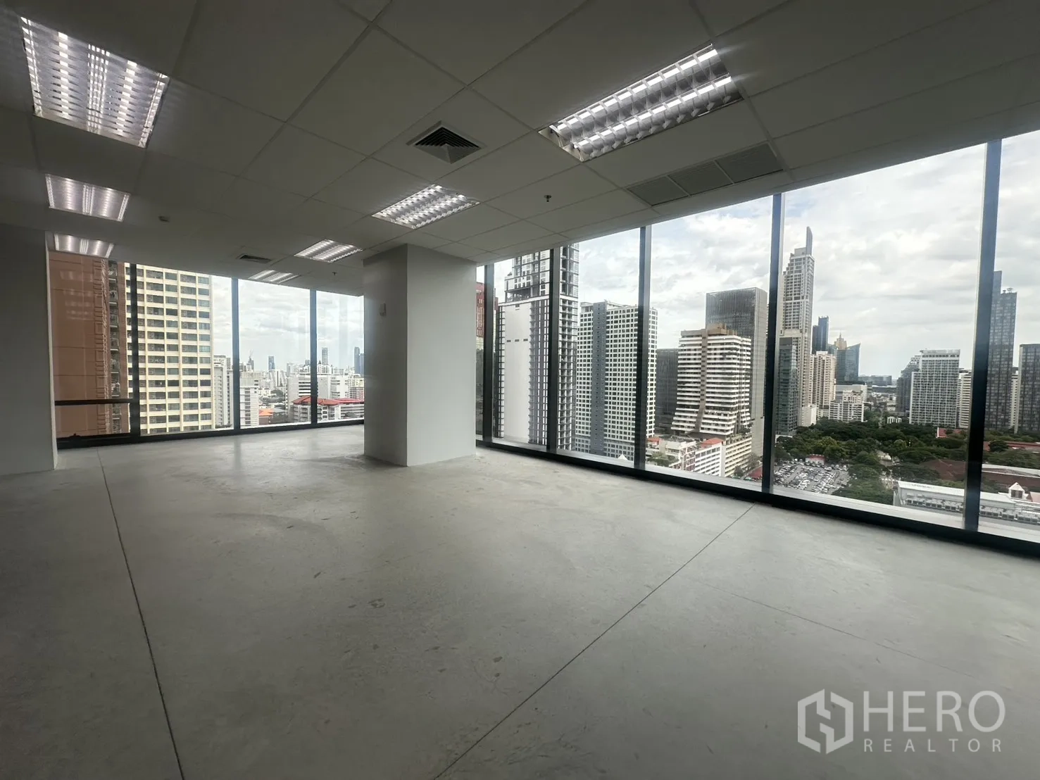 Office Space for rent in Ratchathewi, Bangkok - Open-plan corner office with floor-to-ceiling windows and wide Bangkok skyline views.
