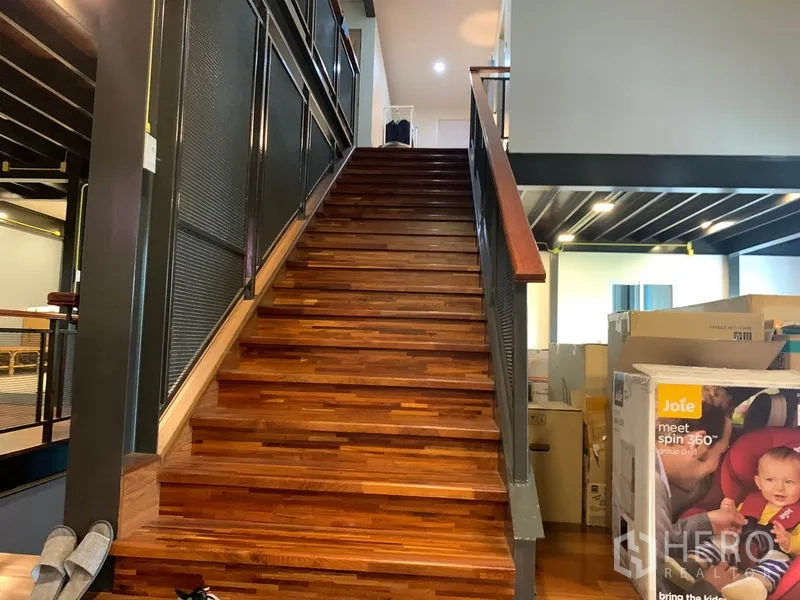 Home Office for rent in Lam Luk Ka, Pathum Thani - Close-up of timber staircase with metal railing leading to the upper floor.