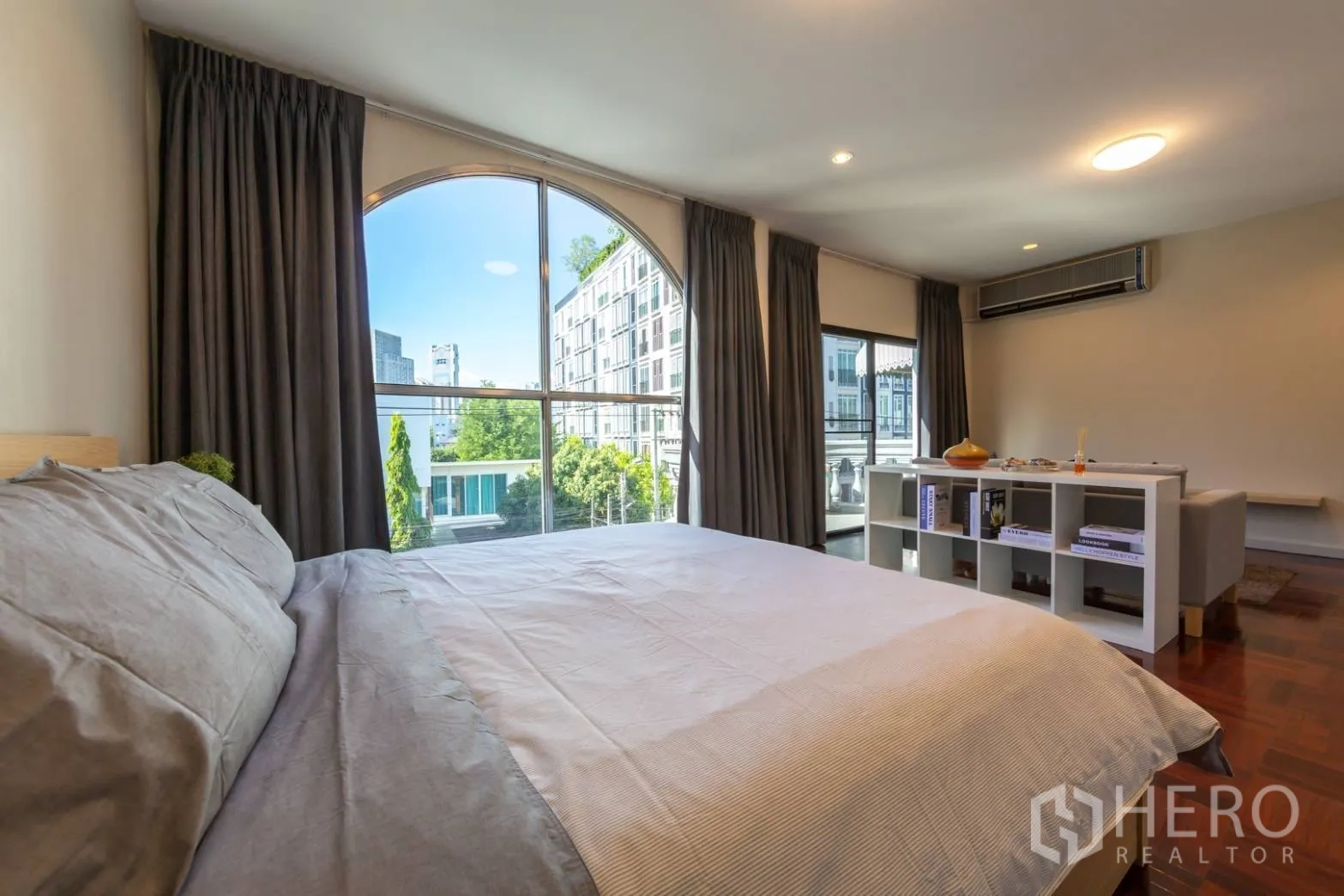 带办公室的家 出租在Bang Rak, Bangkok - 床边望向拱形落地窗，远眺城市景观。