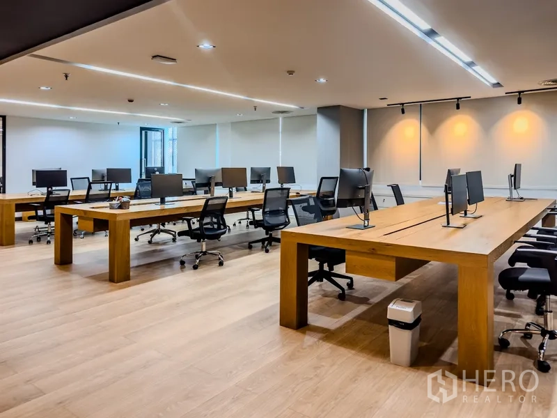 办公室 for rent in Bang Rak, Bangkok - 开放式办公区配大型木质工位、办公椅与顶灯。