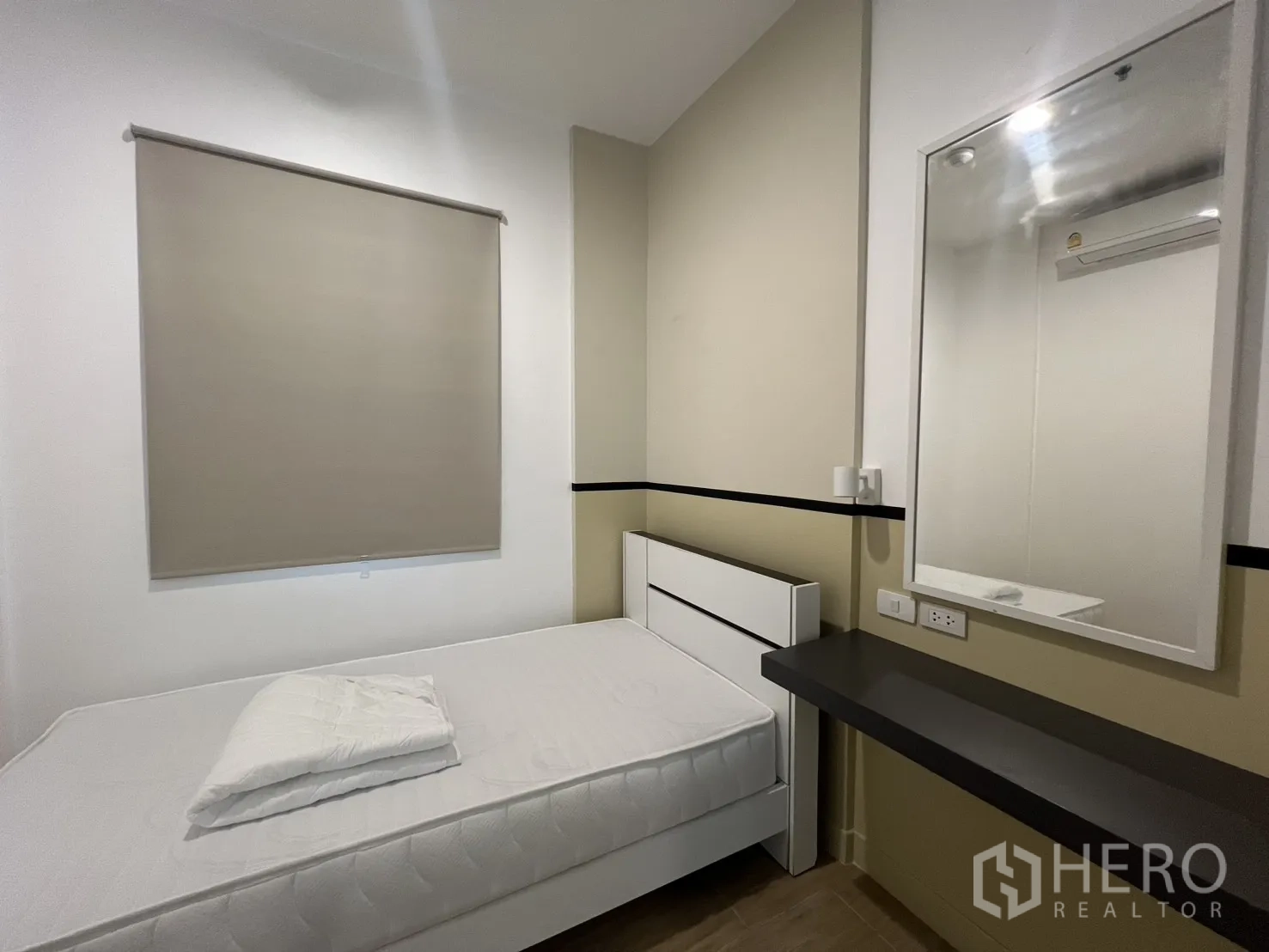 Condominium for rent in Bang Kapi, Bangkok - Second bedroom with a double bed, roller blind, and wall mirror.