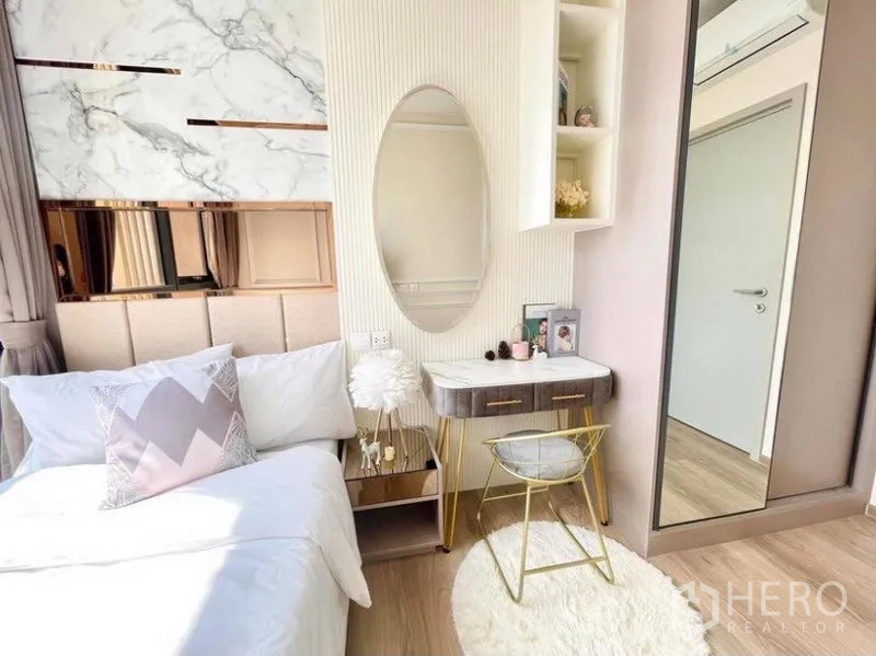 คอนโด ให้เช่าในKhlong Toei, Bangkok - ห้องนอนที่สองอบอุ่น หัวเตียงบุผ้า โต๊ะเครื่องแป้งกระจกวงรี และตู้เสื้อผ้า