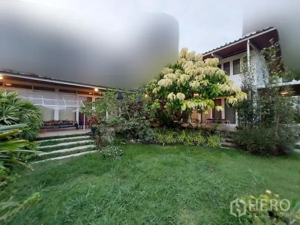 บ้าน ให้เช่าในMueang Samut Prakan, Samut Prakan - สนามหญ้าหน้าบ้านและด้านหน้าบ้านช่วงพลบค่ำ รายล้อมด้วยต้นไม้ใหญ่