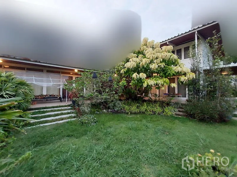 บ้าน ให้เช่าในMueang Samut Prakan, Samut Prakan - สนามหญ้าหน้าบ้านและด้านหน้าบ้านช่วงพลบค่ำ รายล้อมด้วยต้นไม้ใหญ่