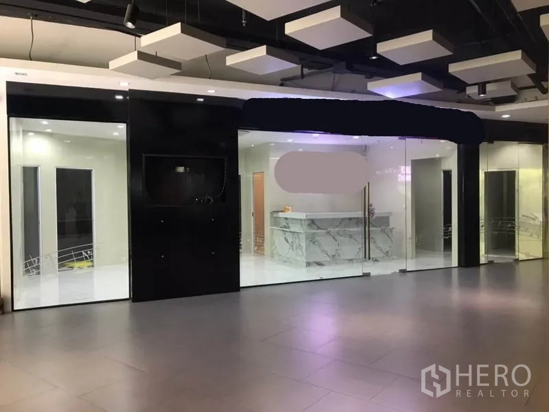 零售空间 出租在Watthana, Bangkok - 走廊内的玻璃门店外立面，可见店内大理石前台。