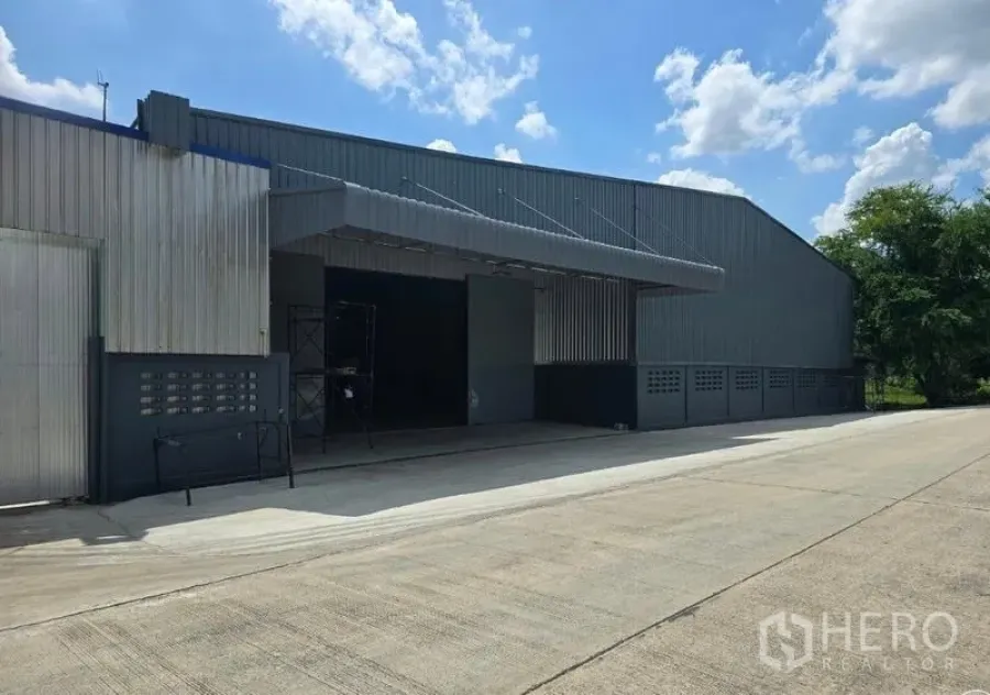 货栈 出租在Sai Noi, Nonthaburi - 开放式仓库地面，宽幅出入口，适合卡车或叉车通行。