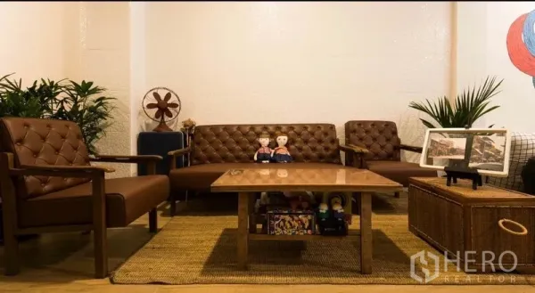 ทาวน์เฮาส์ ให้เช่าในKhlong Toei, Bangkok - มุมนั่งเล่นโทนวินเทจ โซฟาหนังโต๊ะกลาง และต้นไม้กระถาง