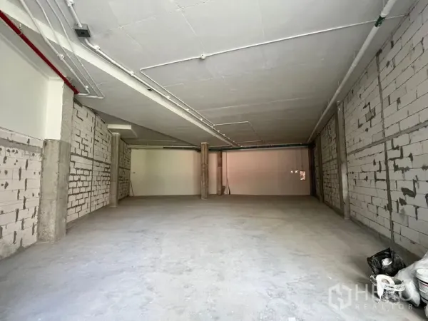 Retail Space for rent - Wide shell retail interior with high ceiling, exposed conduits and open-plan concrete floor ready for fit-out.