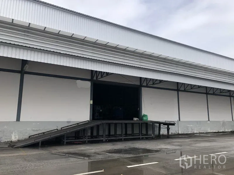 Warehouse for rent in Bang Phli, Samut Prakan - Metal-clad warehouse exterior with a covered loading dock and ramp for truck access in Samut Prakan.