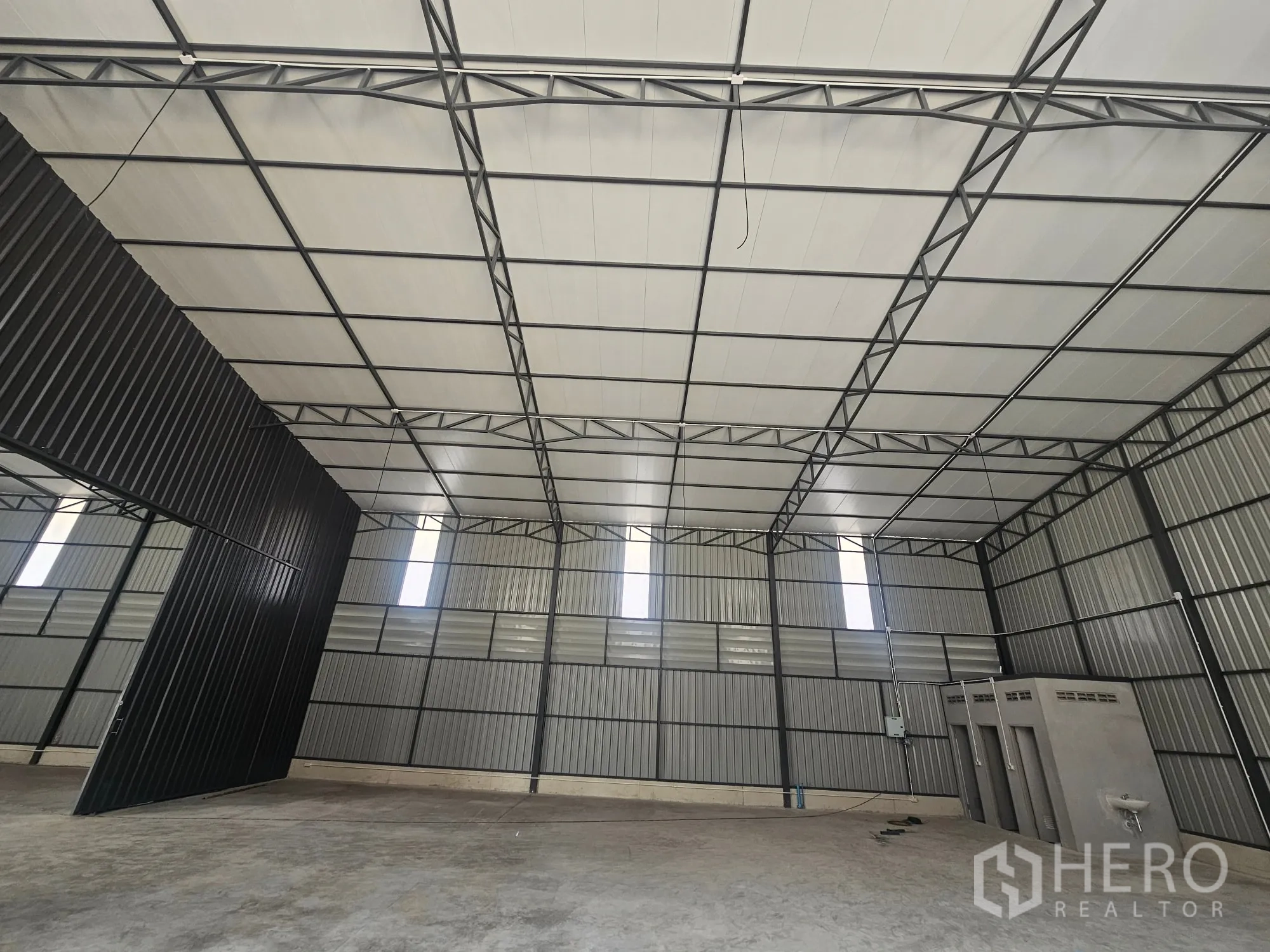 โกดัง for rent in Bang Khen, Bangkok - ภายในโกดังโครงเหล็ก เพดานแผงสำเร็จรูป ประตูบานสไลด์สูง และบล็อกห้องน้ำชิดผนัง