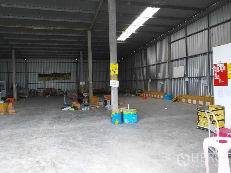 Warehouse for rent in Pak Kret, Nonthaburi - Interior view with steel walls, support columns, and clear-span floor space for storage.