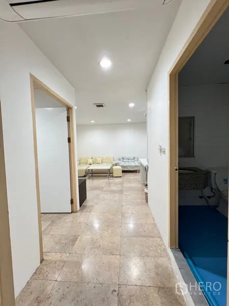 Condominium for rent in Ratchathewi, Bangkok - Hallway leading to the living area and bathroom in neutral tones.