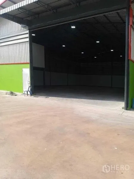 Warehouse for rent in Bang Khun Thian, Bangkok - Open loading entrance showing concrete floor and tall roller door.