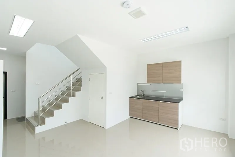 Warehouse for rent in Bang Bo, Samut Prakan - Ground-floor office pantry with cabinets, sink and staircase to upper office.