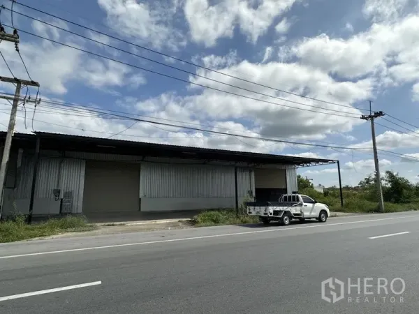 คลังสินค้า ให้เช่าในKhlong Luang, Pathum Thani - ด้านหน้าโกดังติดถนน ผนังเมทัลชีท มีลานขนถ่ายและรถกระบะ คลองหลวง ปทุมธานี
