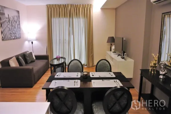 Condominium for rent in Watthana, Bangkok - Open-plan living and dining area with sofa, four-seat table, TV console and floor-to-ceiling curtains on wood flooring.