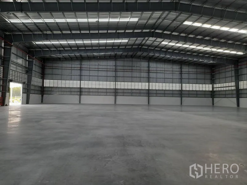 工厂 出租在Mueang Rayong, Rayong - 厂房内部，超高门洞与天窗采光，混凝土地坪平整。