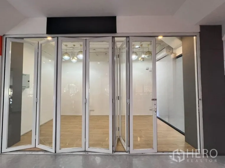 พื้นที่ขายของ for rent in Pathum Wan, Bangkok - มุมมองด้านหน้าร้าน ประตูกระจกบานเฟี้ยมเต็มสูง พื้นไม้โทนอุ่น พร้อมพื้นที่ติดป้าย