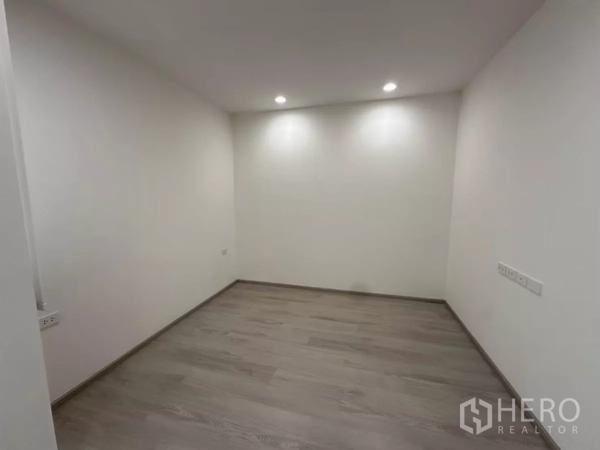 Townhouse for rent in Saphan Sung, Bangkok - Empty bedroom with recessed spotlights and wood flooring ready to furnish.
