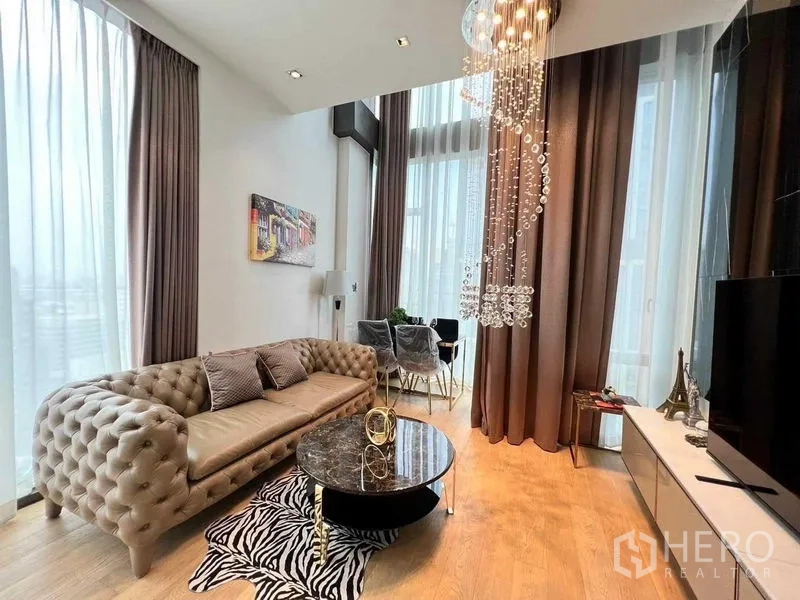 Condominium for rent - Bright living room with tufted sofa, marble coffee table, crystal chandelier and floor‑to‑ceiling windows.