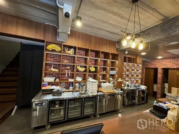 店屋 出租在Watthana, Bangkok - 服务吧台，木质开放式货架、砖墙和不锈钢冷柜