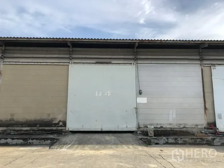 Warehouse for rent in Bang Phli, Samut Prakan - Warehouse exterior with wide sliding loading door and raised loading bay.