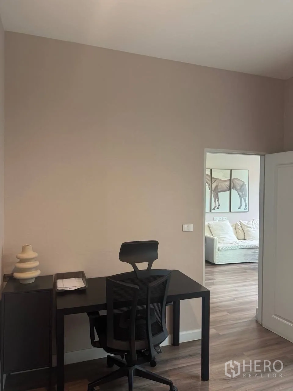 บ้านเดี่ยว for sale in Bang Kruai, Nonthaburi - มุมทำงานขนาดกะทัดรัด มีโต๊ะและเก้าอี้สีดำ มองออกไปยังห้องนั่งเล่น