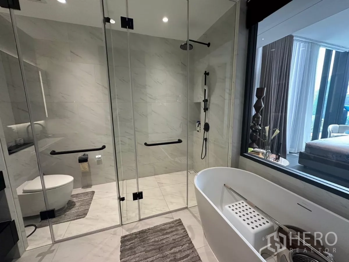 คอนโด ให้เช่าในBang Rak, Bangkok - ห้องน้ำในตัวสไตล์โมเดิร์น อ่างอาบน้ำเดี่ยว ฝักบัวเรนชาวเวอร์ และผนังกระจกลายหินอ่อน