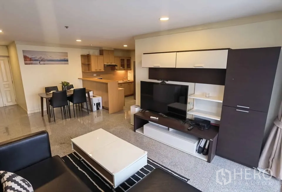 Condominium for rent in Khlong Toei, Bangkok - Spacious living area with media unit, dining set and open kitchen.