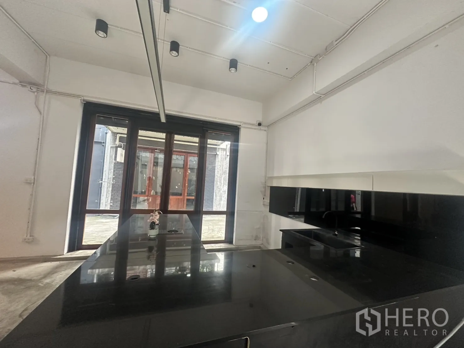 สำนักงานที่บ้าน ให้เช่าในPathum Wan, Bangkok - มุมเคาน์เตอร์และพื้นที่จัดแสดง หันสู่ผนังกระจกและประตูไม้กระจก