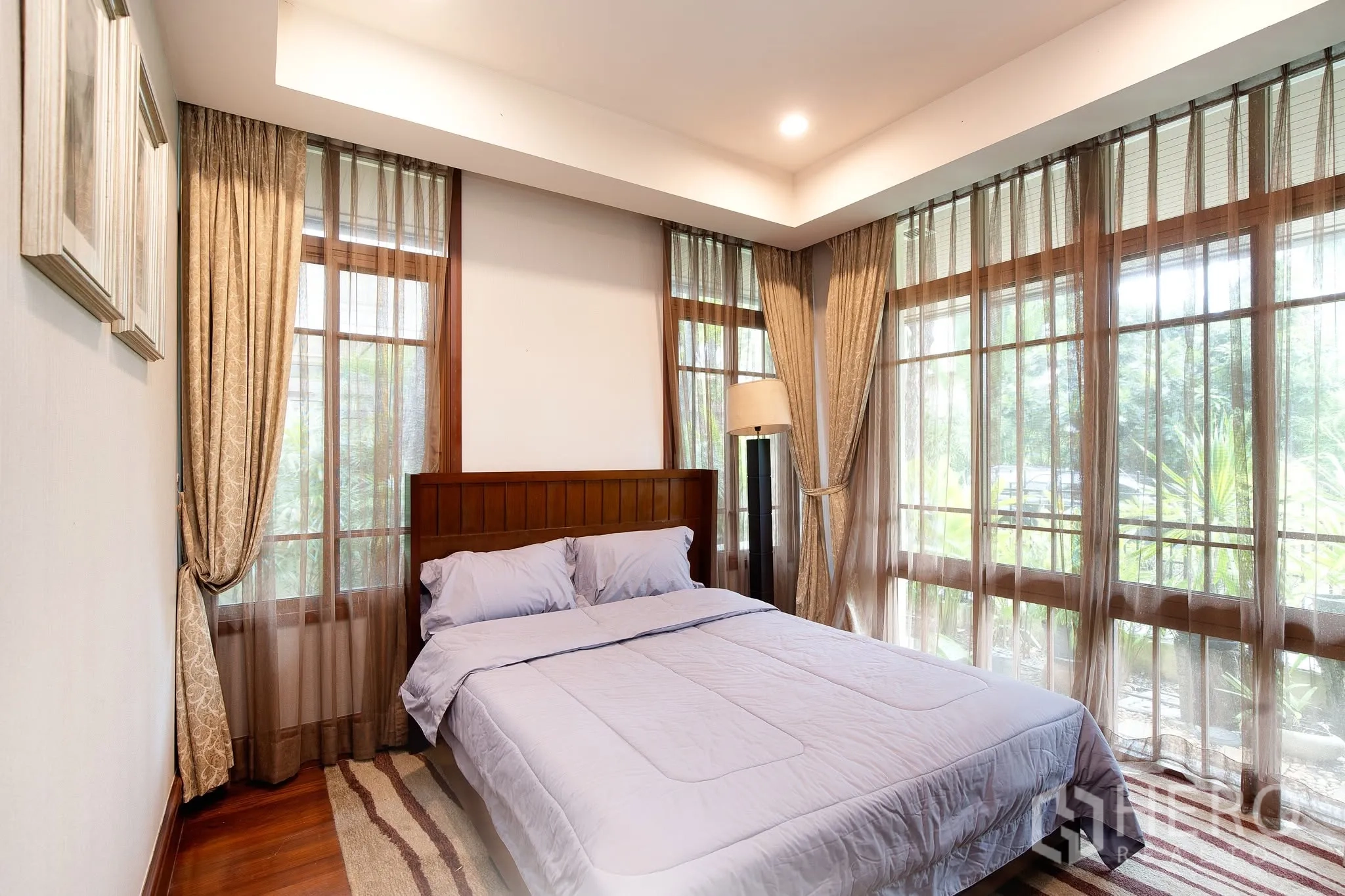 独栋房屋 for rent or sale in Watthana, Bangkok - 舒适卧室设转角落地窗、纱帘与双人床。