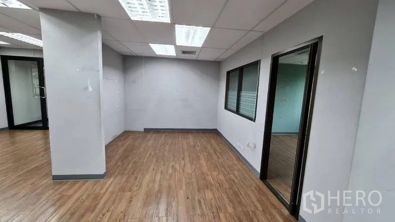 Office Space for rent in Watthana, Bangkok - Hallway view with columned area leading to a bright open office.