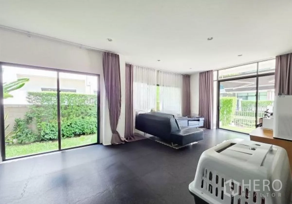 Detached House for sale in Bang Kapi, Bangkok - Bright open-plan living room with floor-to-ceiling sliding glass and garden views.