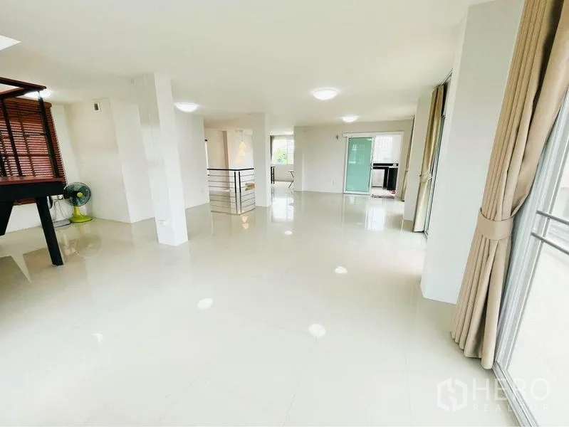 Home Office for rent in Bang Sue, Bangkok - Open-plan upper floor with white columns, large windows and access to a balcony.