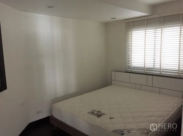 公寓 出租在Sathon, Bangkok - 温馨卧室，大窗配白色百叶帘，加大床垫与极简床头板。