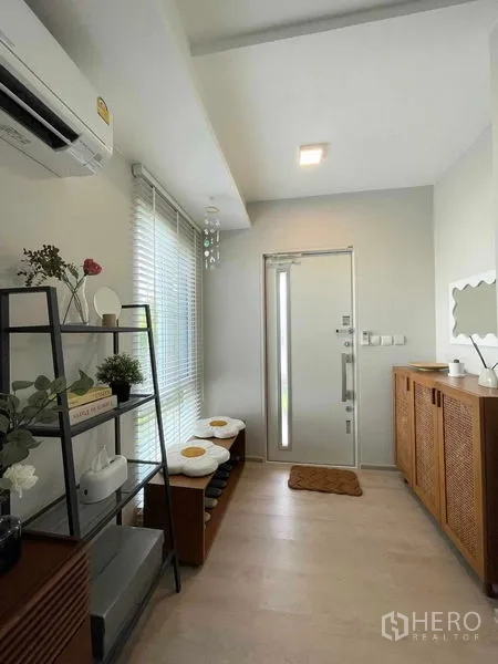 บ้าน ให้เช่าหรือขายในPrawet, Bangkok - โถงทางเข้า บ้านมีชั้นวางของ ม้านั่ง แอร์ และประตูหน้ากระจก โทนสีอบอุ่น