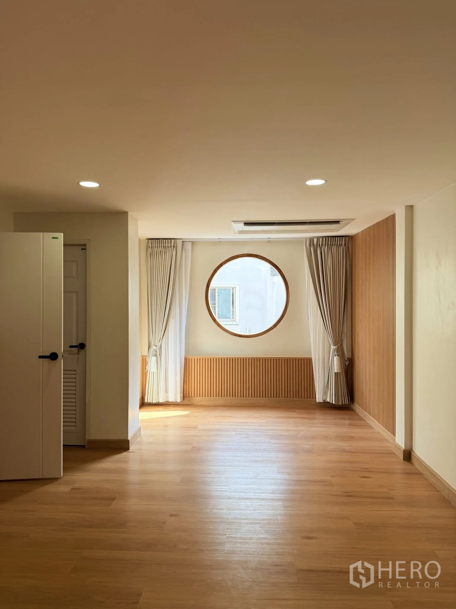 联排别墅 for rent or sale in Yan Nawa, Bangkok - 采光充足的起居区，木地板、圆形窗与窗帘