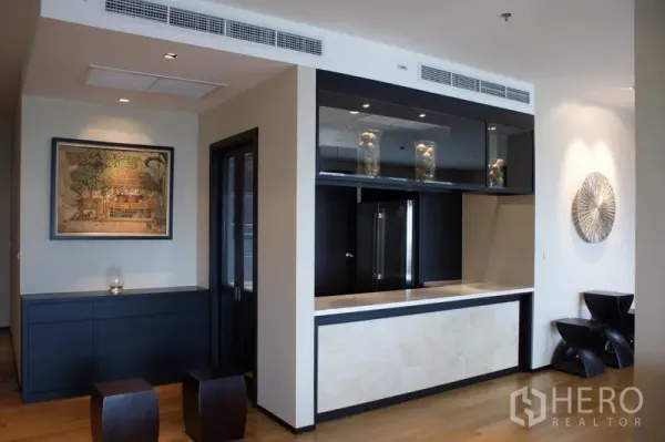 Condominium for rent in Watthana, Bangkok - Modern condo interior with built-in bar, glass cabinets, and warm wood flooring.