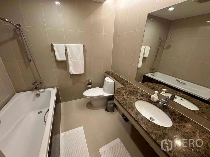 คอนโด ให้เช่าหรือขาย - ห้องน้ำสไตล์โมเดิร์นพร้อมอ่างอาบน้ำ เคาน์เตอร์หินอ่อน และกระจกบานใหญ่