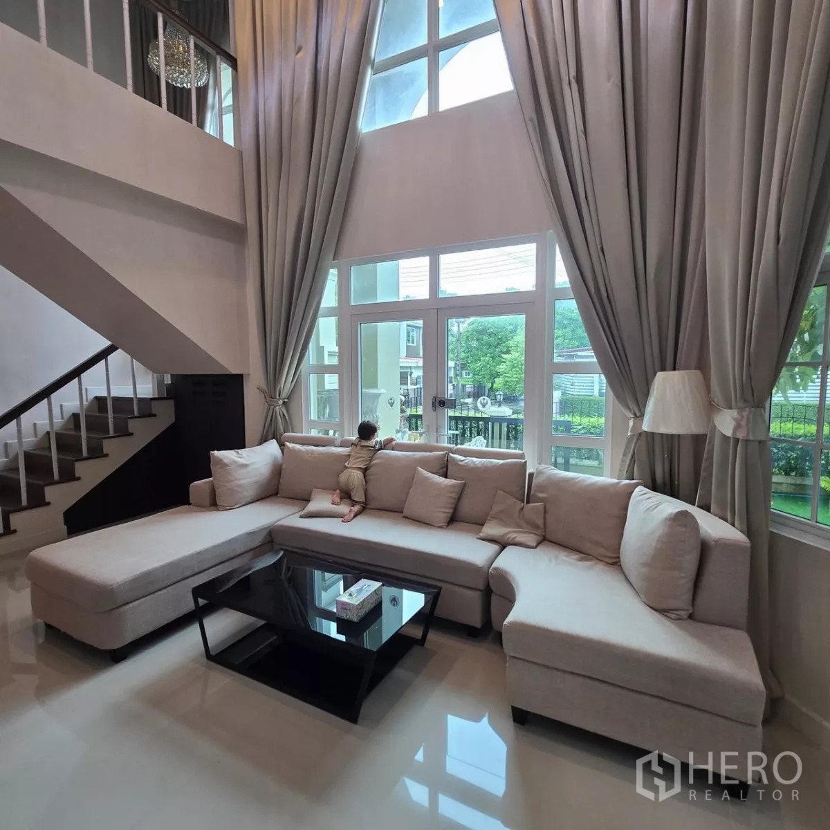 บ้าน ให้เช่าในMueang Pathum Thani, Pathum Thani - ห้องนั่งเล่นสว่าง หน้าต่างสูง ผ้าม่านยาว เปิดสู่เฉลียง