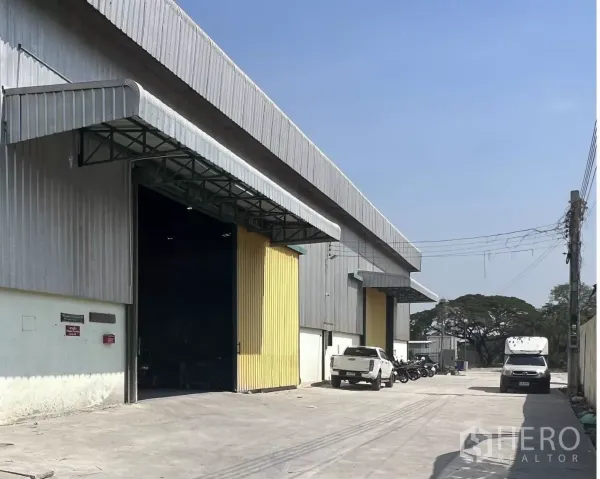 Warehouse for rent in Lat Krabang, Bangkok - Wide concrete driveway and parking in front of warehouse bays, suitable for truck access.
