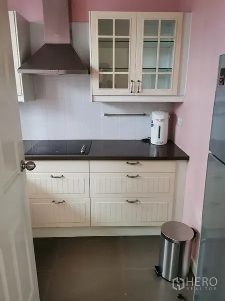 联排别墅 出租在Wang Thonglang, Bangkok - 嵌入式厨房，白色柜体、黑色台面、灶台与不锈钢烟机。